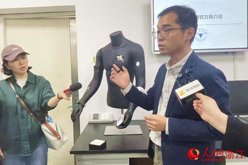浙江大學生物醫學工程與儀器科學學院特聘研究員梁波介紹研究所研制的穿戴式血氧指環。人民網記者 王麗瑋攝