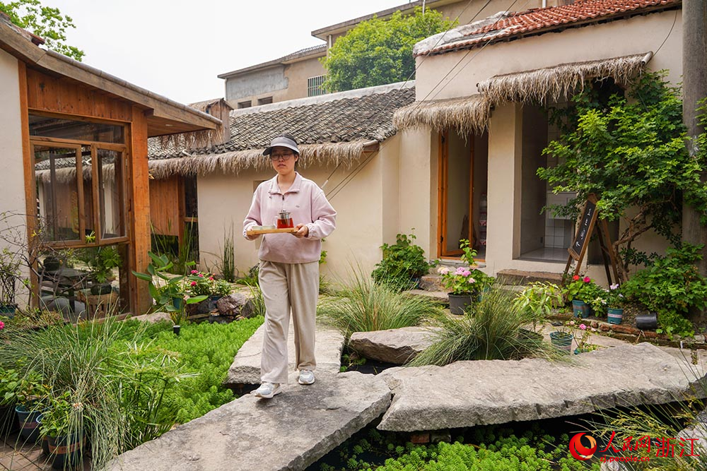 在浙江省慈溪市浒山街道大河口艺术部落，茶艺师在给客人送茶。人民网 章勇涛摄