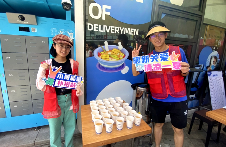 學生志願者為“小哥”送上夏日清涼。
