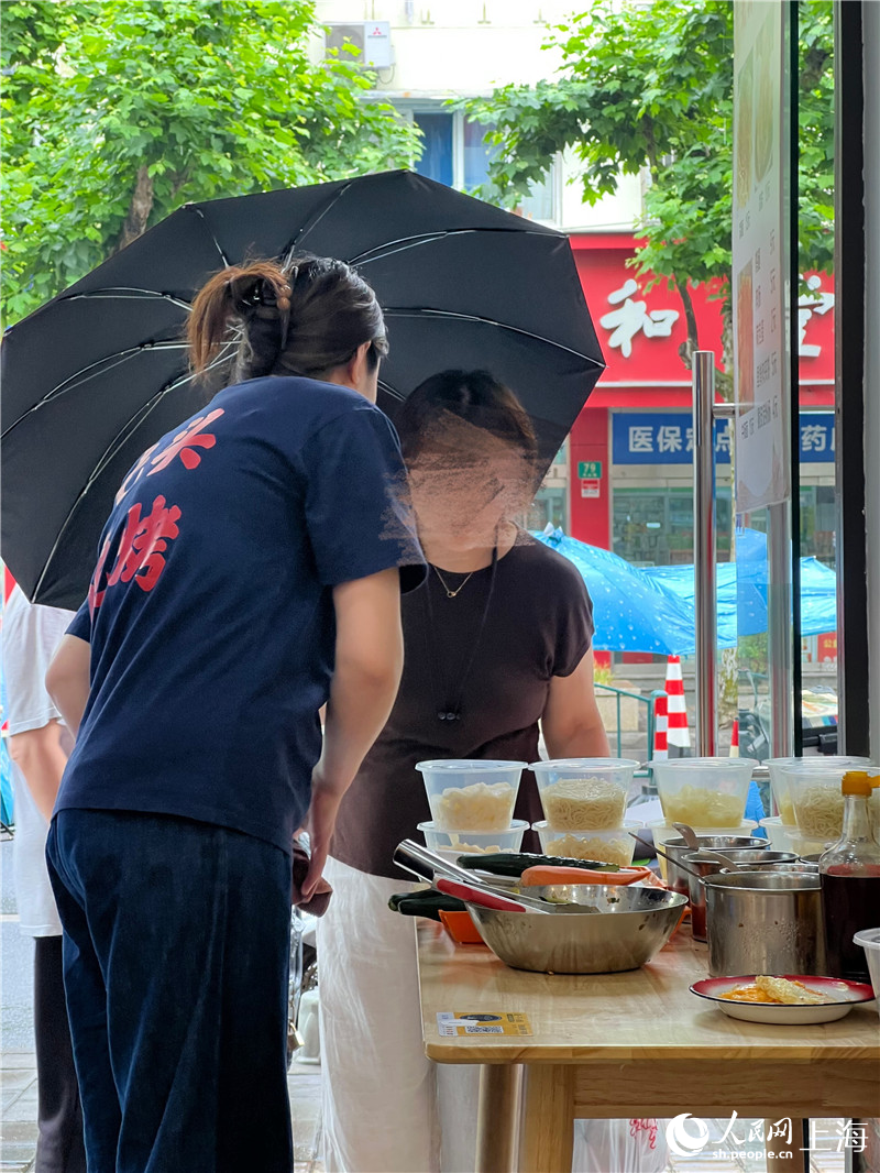 为了多赚钱，从下午4点到彻底天黑前的空档，徐姐还在店门口支起了卖冷面的小桌。人民网记者 沐一帆摄