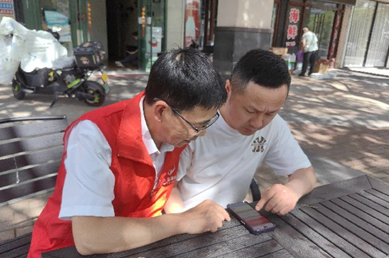 志願者指導消費者參與第三屆全國煙草管理法律法規知識網上答題。舟山市煙草專賣局供圖