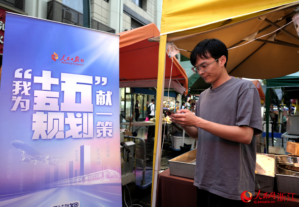 近日，在浙江杭州武林夜市，游客、商户积极参与“我为‘十五五’规划献一策”活动。人民网 陈陆洵摄