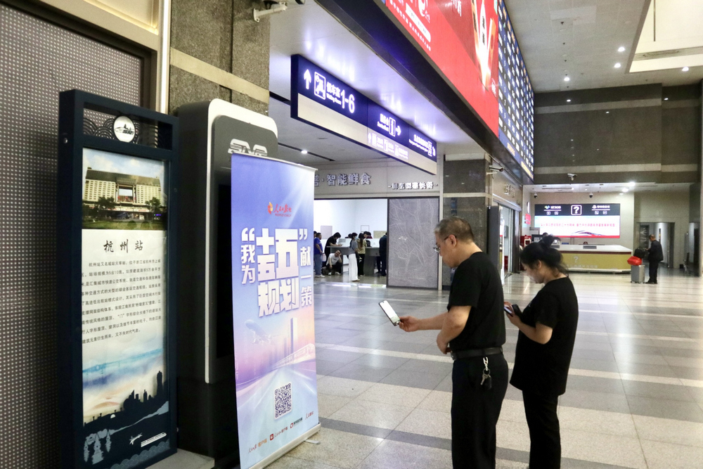 在杭州城站，乘客掃碼參與活動。李採恩攝