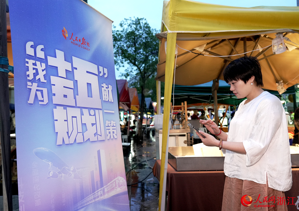 在杭州武林夜市，游客、商戶積極參與“我為‘十五五’規劃獻一策”活動。人民網 陳陸洵攝 