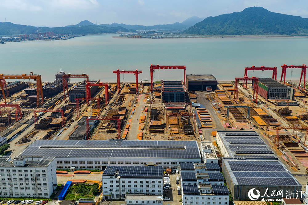 在浙江省寧波市象山縣石浦鎮打鼓峙臨港裝備制造基地，巨大的龍門吊緩緩移動，吊臂車在船體間穿梭自如，呈現一派熱火朝天的生產景象。人民網 章勇濤攝