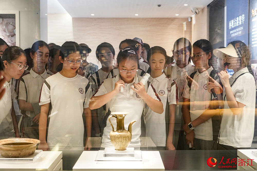 温州朔门古港遗址考古成果展现场，学生们驻足凝视一件件出土文物。人民网 章勇涛摄