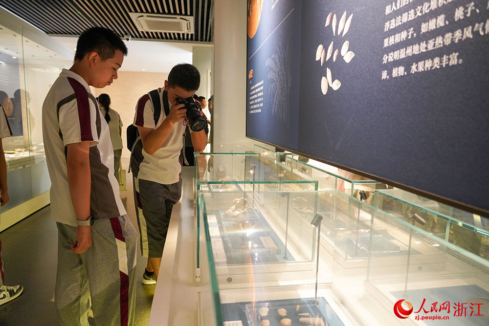 温州朔门古港遗址考古成果展现场，学生们驻足凝视一件件出土文物。人民网 章勇涛摄