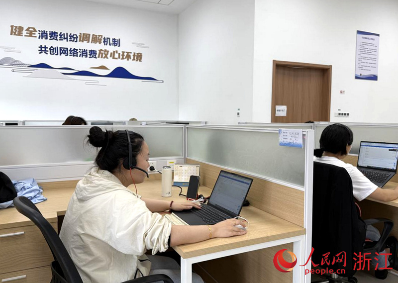 余杭區市場監管局網監分局的人工調解員正在處理網絡消費投訴案件。人民網 方彭依夢攝
