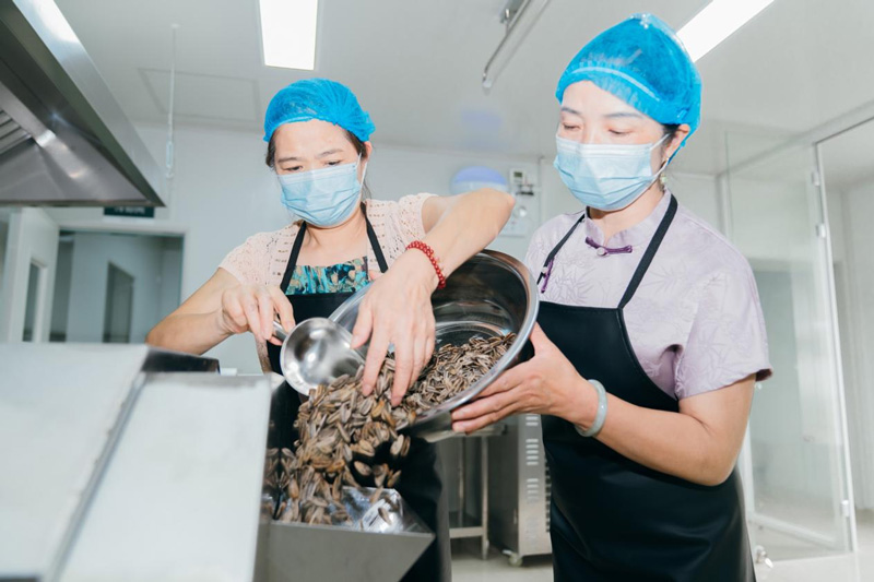 村民在“百丈百味”共富工坊炒制新一批瓜子。余杭区委宣传部供图