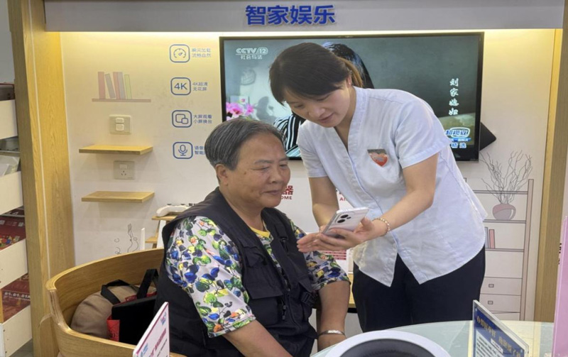 工作人員向老年用戶講解智能手機使用方法。浙江移動供圖