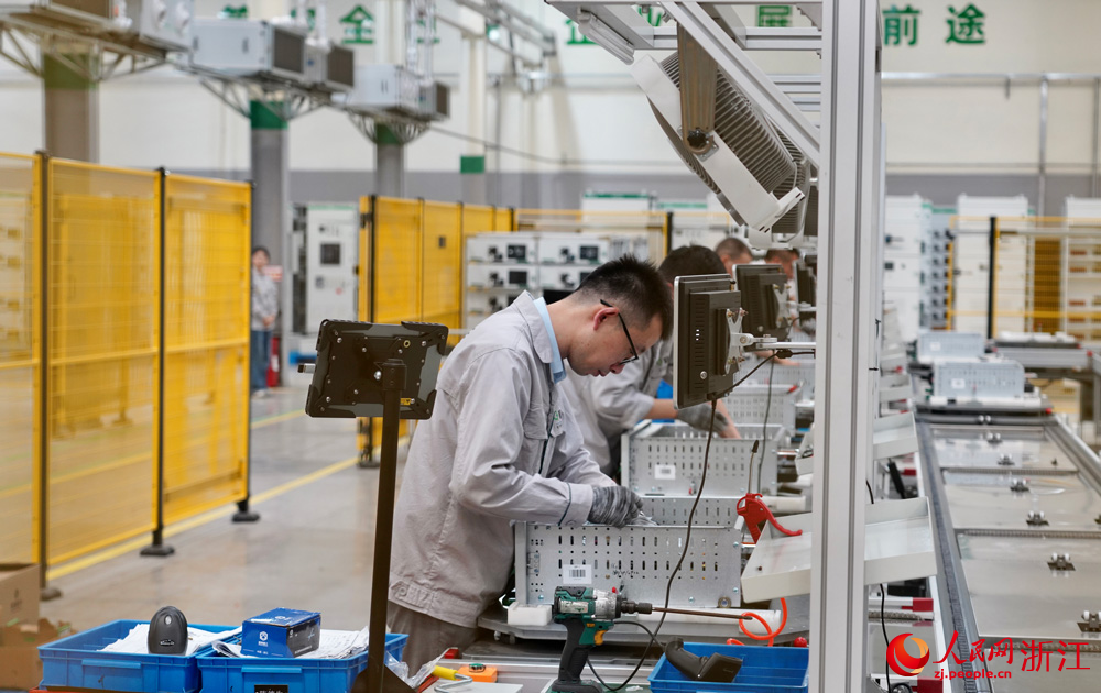 极能数字装备制造中心内,工人们正专注地组装新一代数字配电柜。人民网记者 郭扬摄