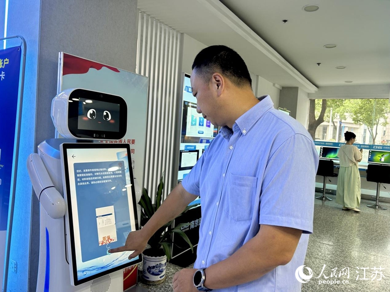 工作人員正在測試智慧醫保服務機器人。人民網 王丹丹攝