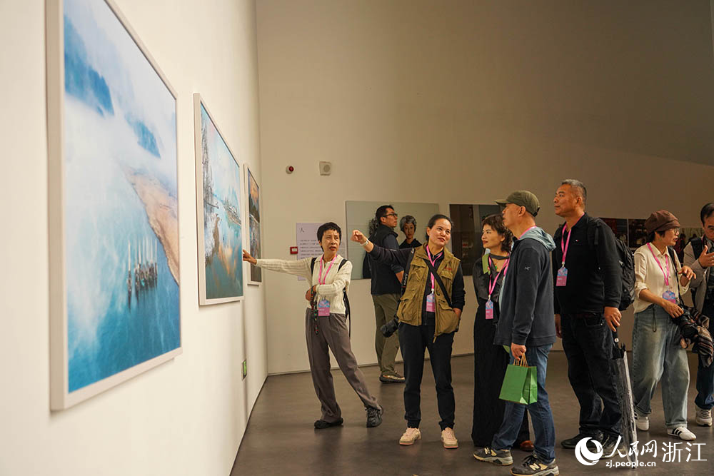 观众在浙江省丽水市莲都区古堰画乡观看全国摄影百县联盟交流展。人民网 章勇涛摄