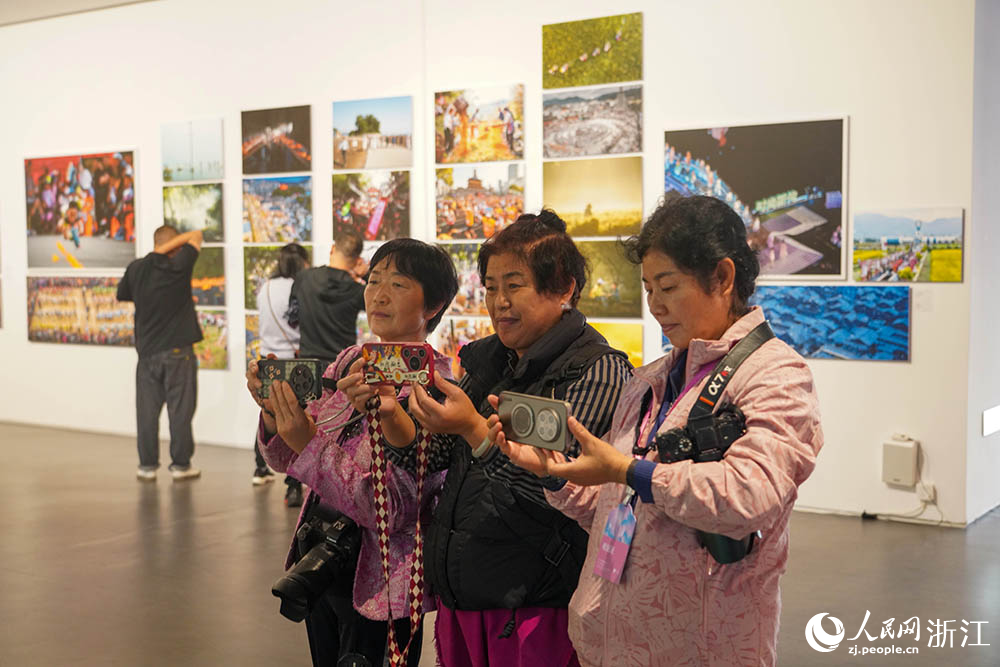 观众在浙江省丽水市莲都区古堰画乡观看全国摄影百县联盟交流展。人民网 章勇涛摄