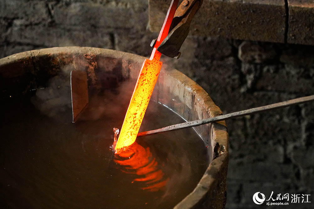 在浙江省龙泉市沈广隆剑铺，铸剑师对宝剑剑坯进行淬火。人民网 章勇涛摄
