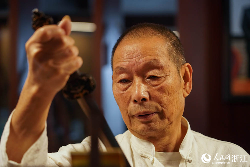 在浙江省龙泉市沈广隆剑铺，沈新培在查看龙泉宝剑成品。人民网 章勇涛摄