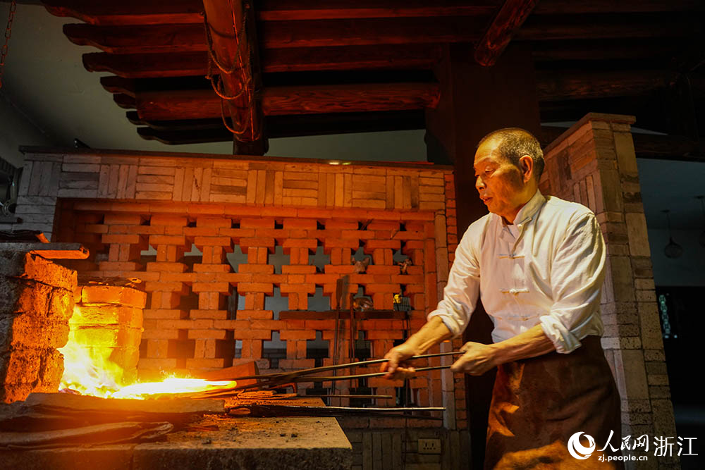 在浙江省龙泉市沈广隆剑铺，沈新培正在进行宝剑锻打的准备工序。人民网 章勇涛摄