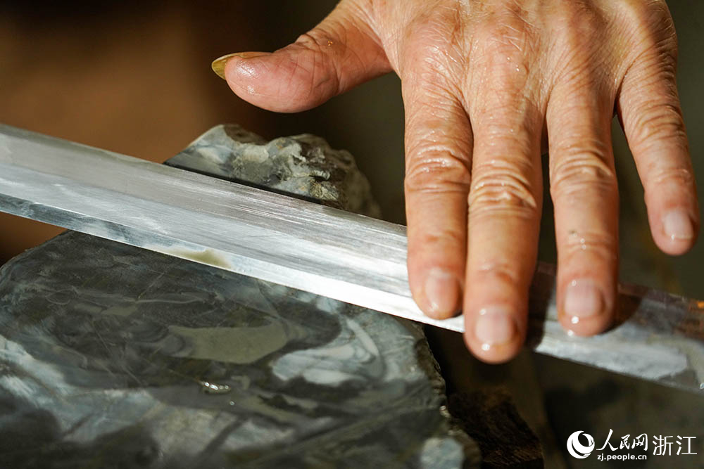 在浙江省龙泉市沈广隆剑铺，沈新培正在精磨宝剑剑坯。人民网 章勇涛摄