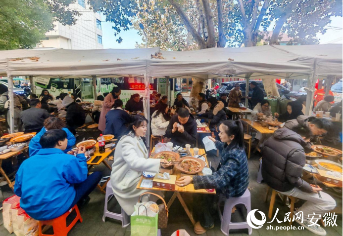 迎春街上，游客們品嘗廣德燉鍋。人民網記者 王銳攝