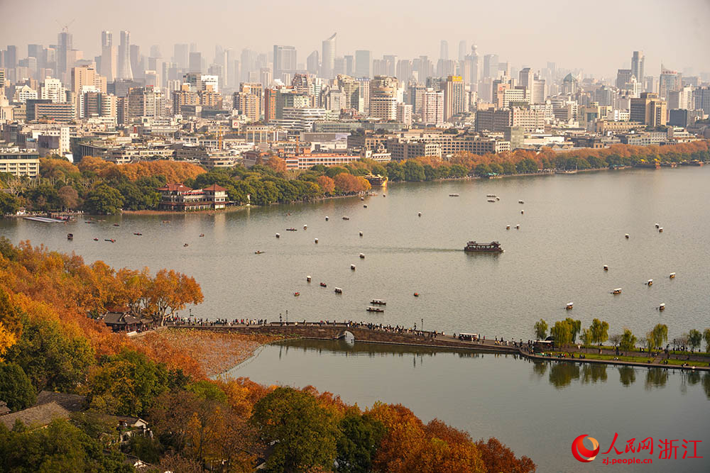 城市天际线与湖光山色相映成趣，市民游客徜徉其间。人民网 章勇涛摄