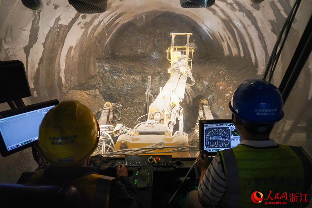 在浙江省义龙庆高速龙泉段施工现场,智能三臂凿岩台车精准作业。人民网 章勇涛摄