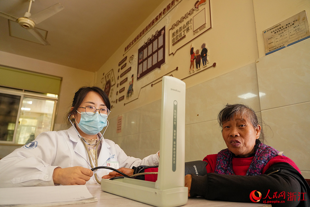浙江省台州市黃岩區北城街道后庄村暖意濃濃,醫護人員為老人測量血壓。人民網 章勇濤攝