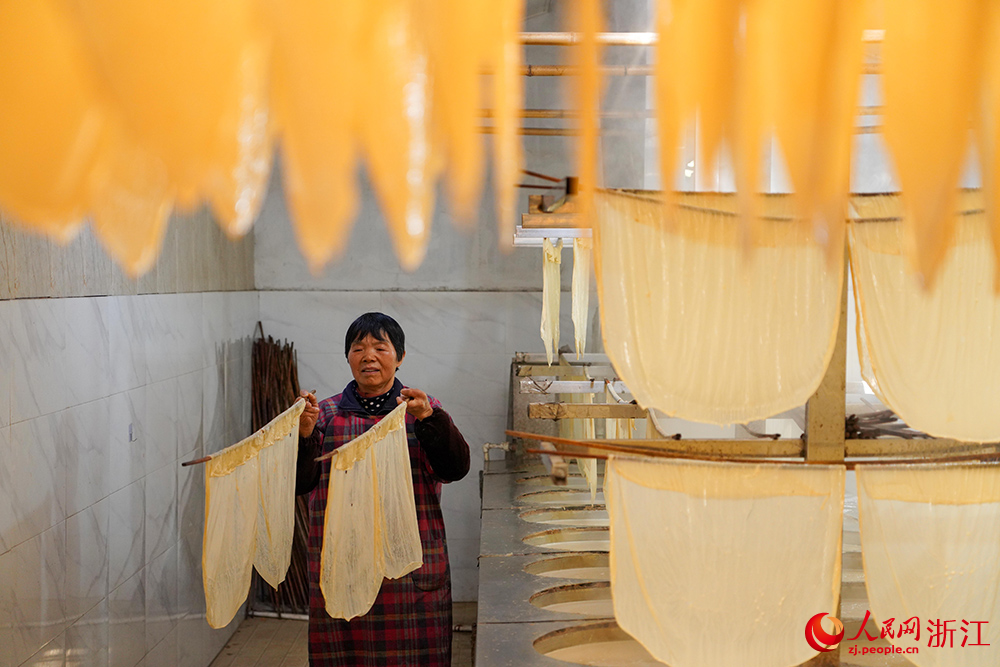 嵊州市崇仁镇的一豆腐皮作坊内雾气缭绕、豆香四溢，村民正忙着制作豆腐皮。人民网 章勇涛摄