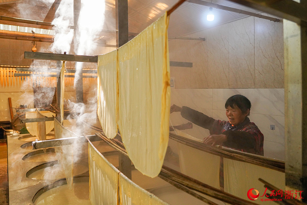 嵊州市崇仁镇的一豆腐皮作坊内雾气缭绕、豆香四溢,村民正忙着制作豆腐皮。人民网 章勇涛摄