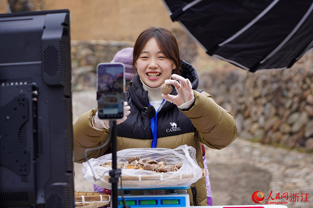 1月21日，白鹤尖共富工坊直播团队依托“流动便民共富车”，现场推介当地特色农产品。人民网 章勇涛摄