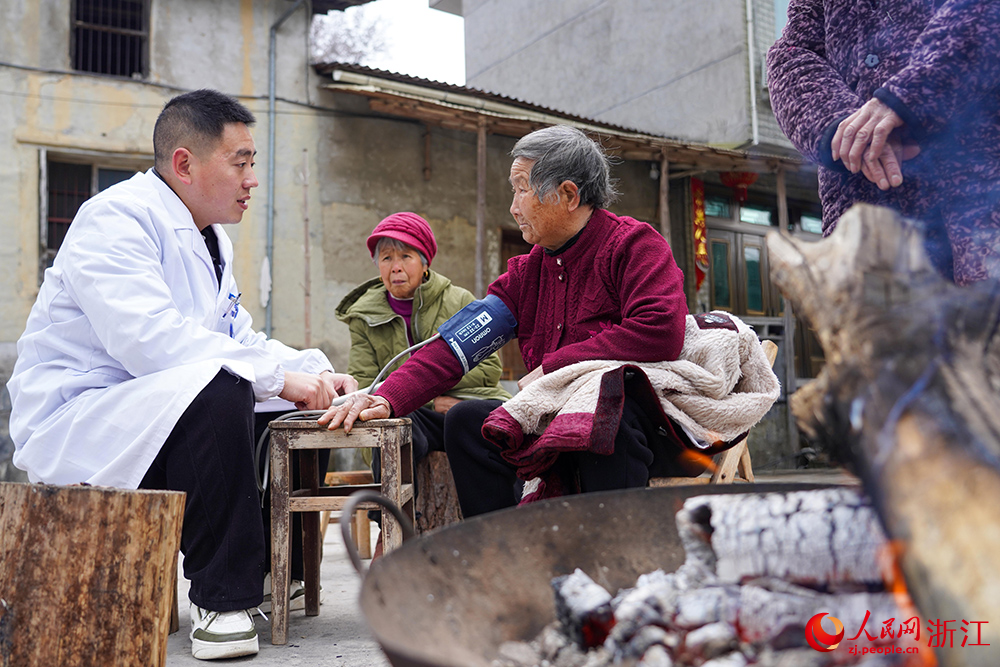 在浙江省麗水市雲和縣石塘鎮，家庭醫生江傳彬為老人測量血壓。人民網 章勇濤攝
