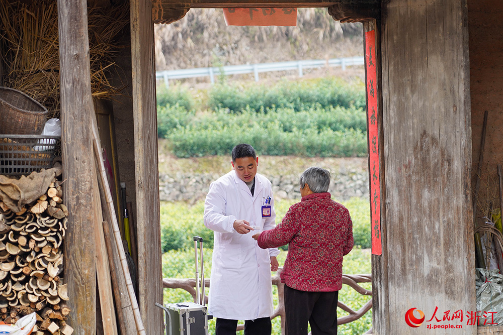 在浙江省麗水市雲和縣石塘鎮，家庭醫生江傳彬為老人講解藥品如何使用。人民網 章勇濤攝