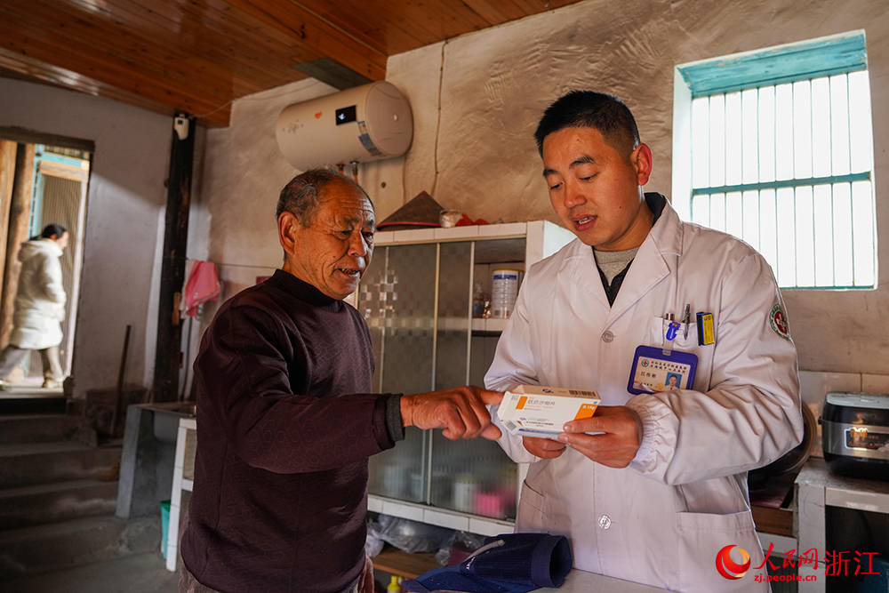 在浙江省丽水市云和县石塘镇,家庭医生江传彬为老人讲解药品如何使用。人民网 章勇涛摄