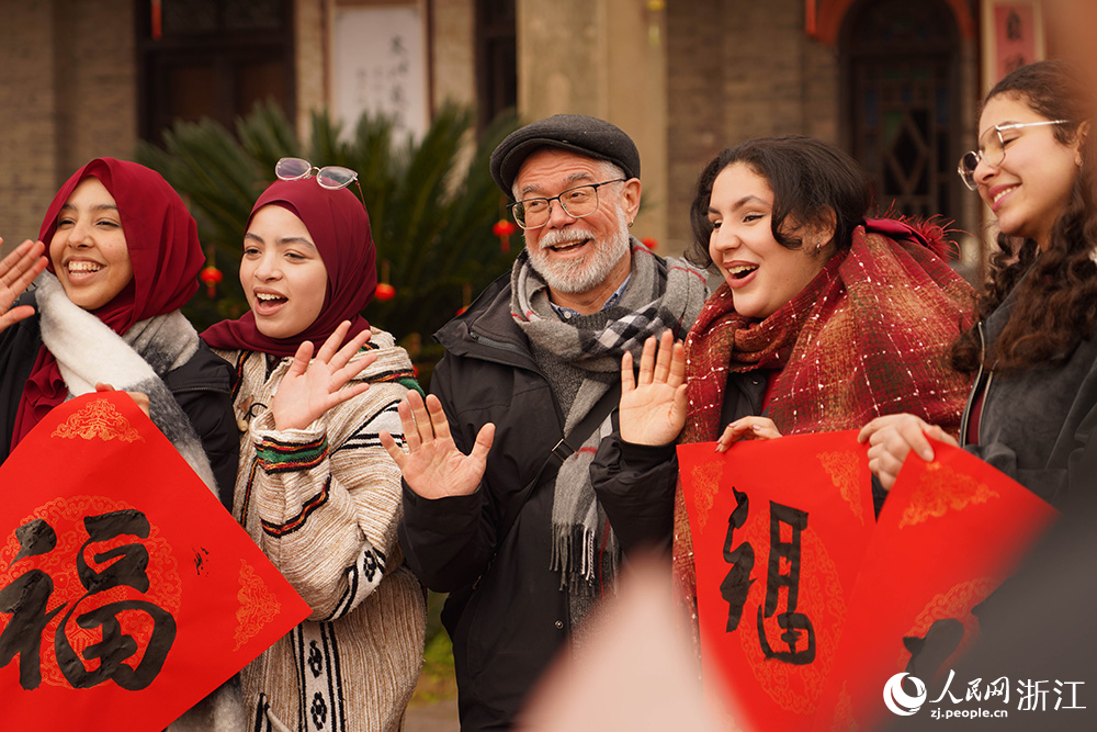 2月1日，外籍友人在宁波市江北区慈城镇手持“福”字，笑容满面感受中国年味。人民网 章勇涛摄