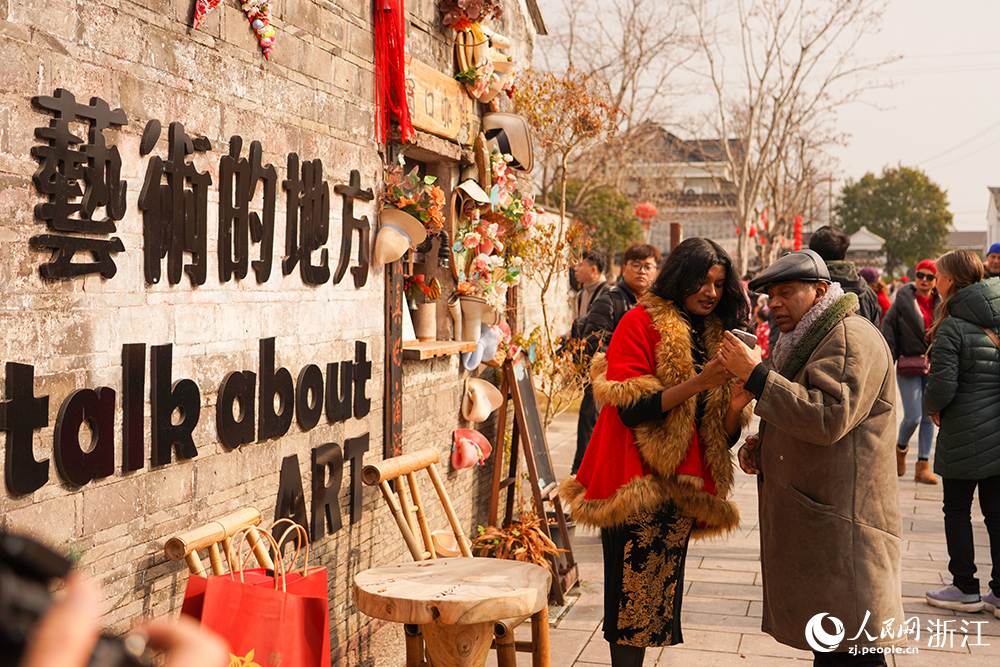 2月1日，外籍友人在宁波市江北区慈城镇一处砖墙前驻足拍照。人民网 章勇涛摄