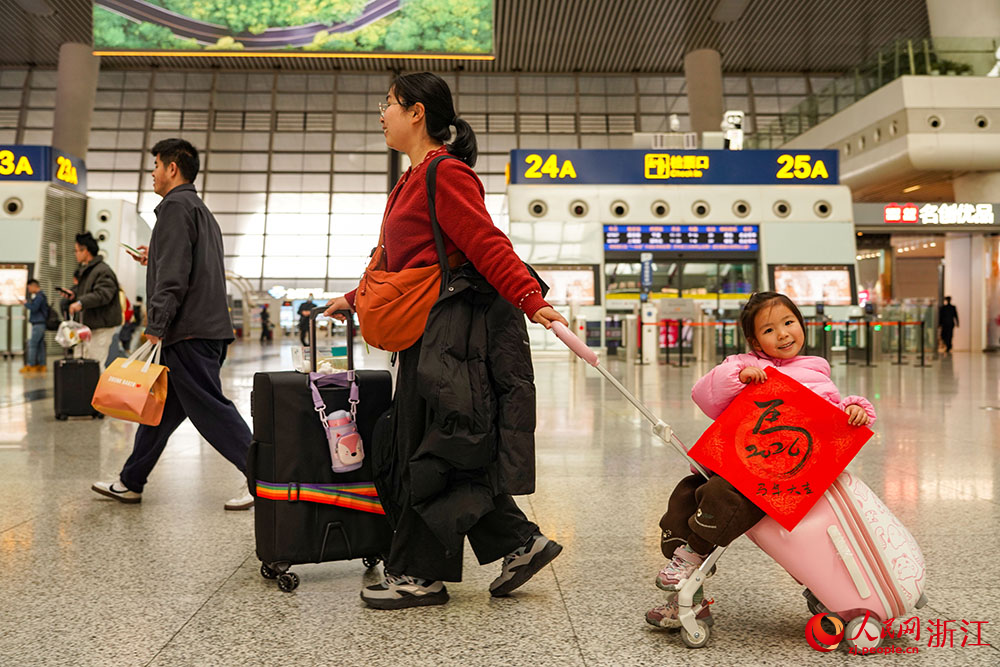 2月2日，2026年春运大幕开启。杭州东站候车大厅人头攒动，孩童手举“马”字，与家人共同奔赴团圆。行李箱轮声辘辘，交织成温暖的春节序曲。人民网 章勇涛摄