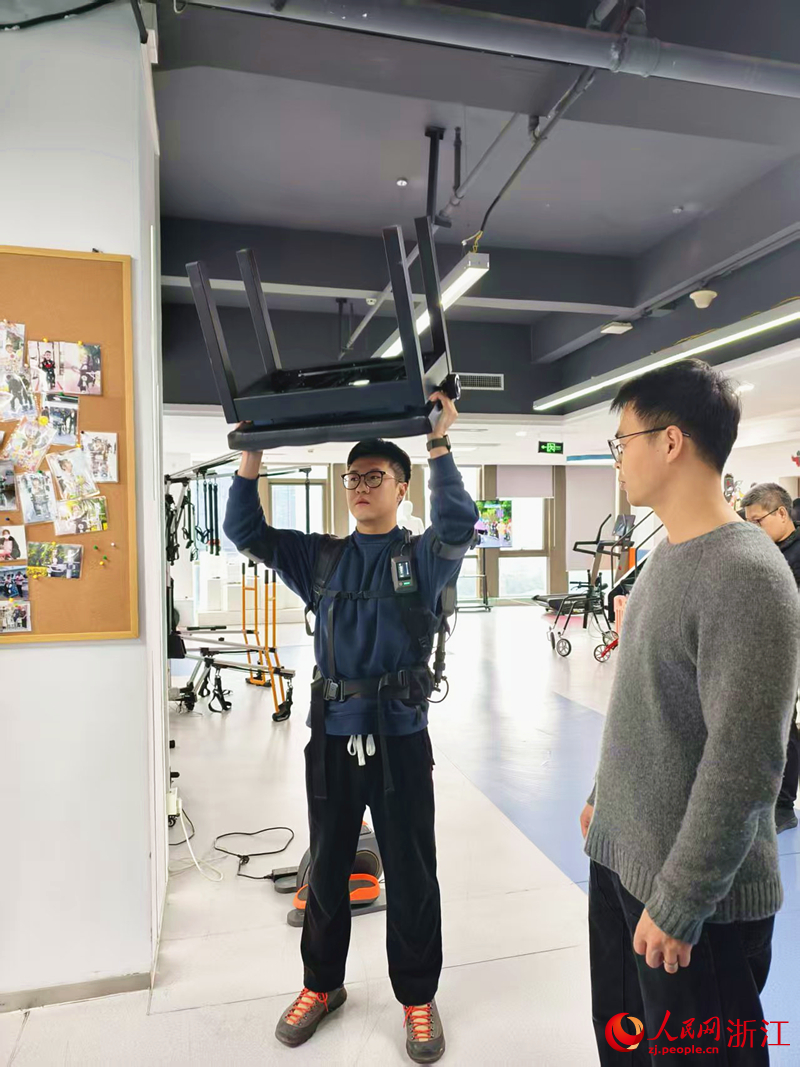 一位青年正在體驗工業搬運外骨骼機器人。人民網記者 康夢琦攝