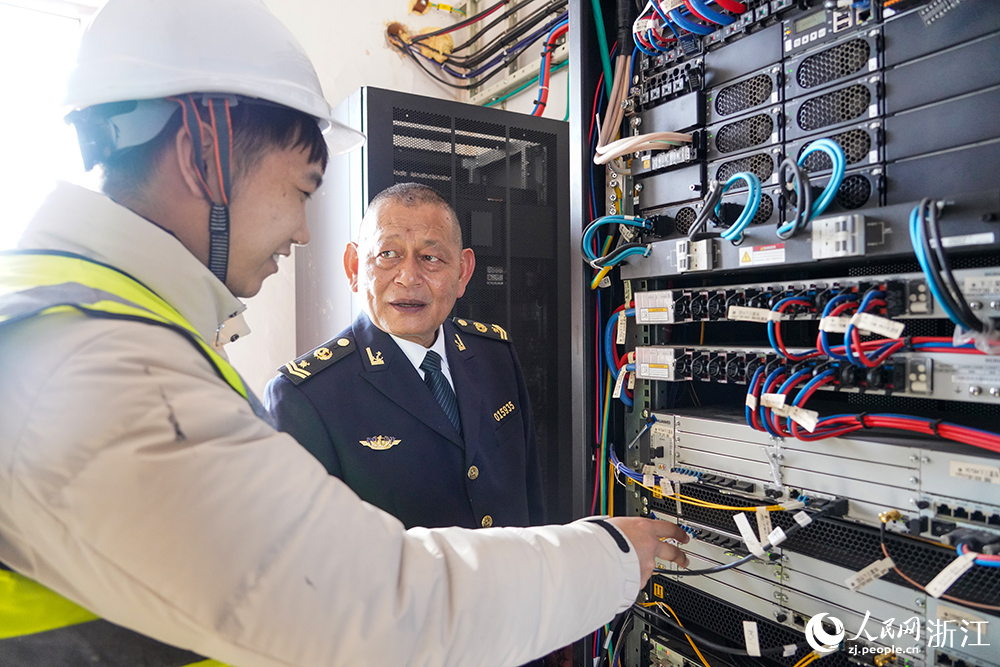 黃海鬆在和中國移動工作人員了解設備檢修情況。人民網 章勇濤攝