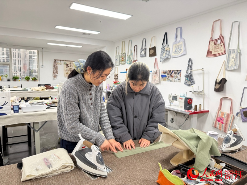 春節將至，年輕人選擇親手為寵物縫制“新年戰袍”。人民網 程欣攝