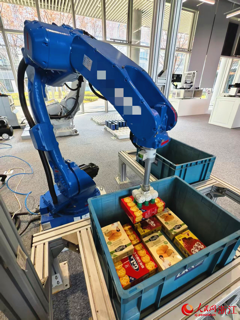 装上了“眼睛”的码垛机器人将规格不一的货物整齐码放。人民网记者 康梦琦摄