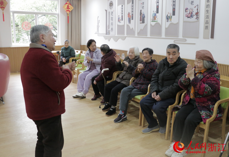 “新春歌会”上，李艳辉（右一）热情地与唱歌老人互动。人民网记者 王丽玮摄