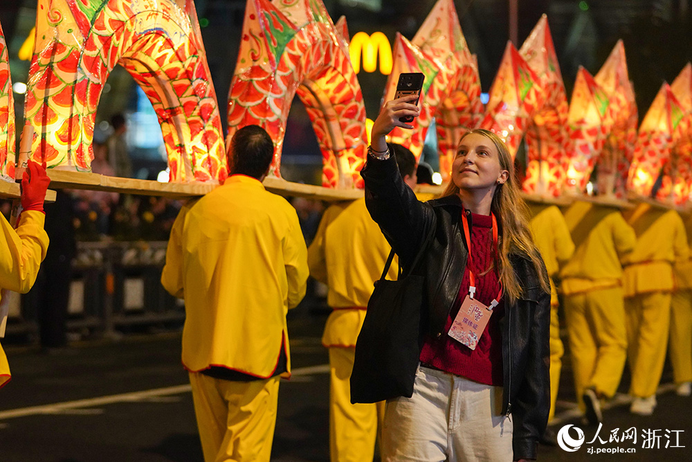 3月2日,在浙江省麗水市區,來自俄羅斯的自媒體博主卡佳觀看祥龍燈彩巡游。人民網 章勇濤攝