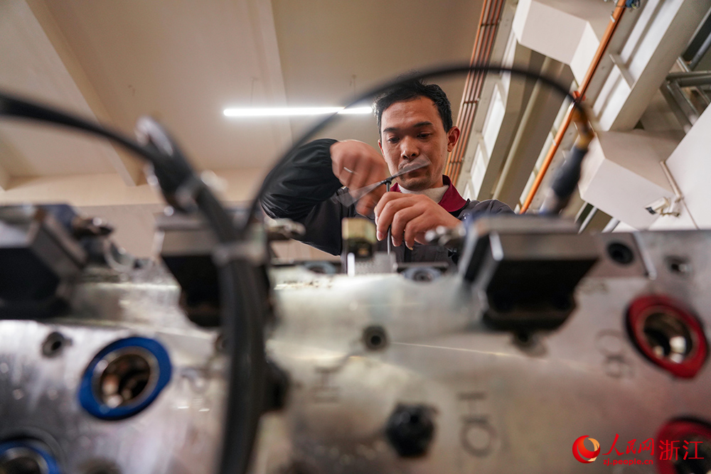 在寧波市寧海縣一家企業,工人在進行滑塊裝配和滑塊動作檢查。人民網 章勇濤攝