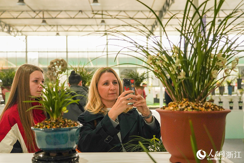 3月13日，浙江省紹興市柯橋區漓渚鎮，外籍游客在觀賞春蘭。人民網 章勇濤攝