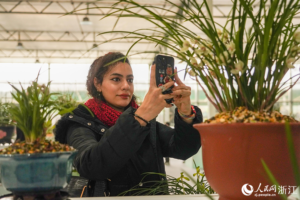 3月13日，浙江省紹興市柯橋區漓渚鎮，外籍游客在觀賞春蘭。人民網 章勇濤攝