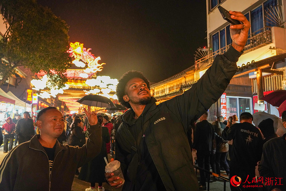 3月20日晚，在二月二灯会现场，外国友人与市民合影留念。人民网 章勇涛摄