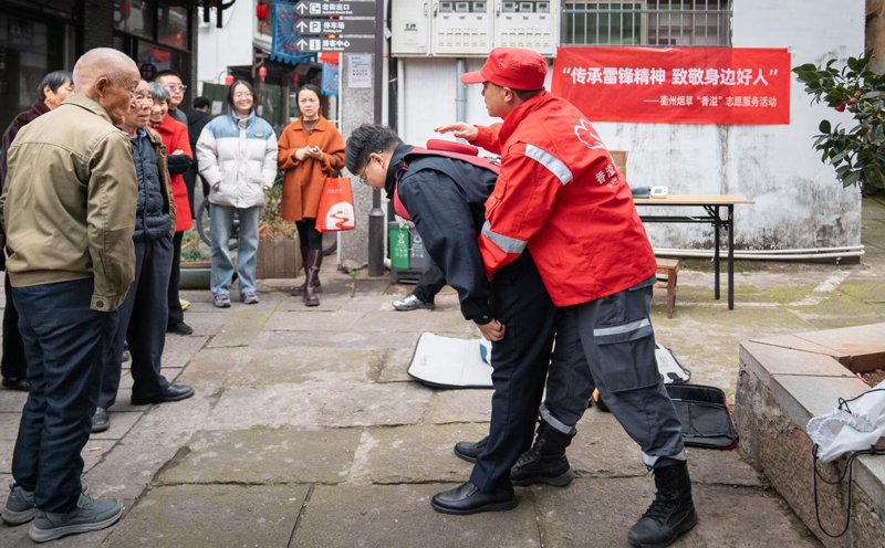 “香溢”志愿者为村民演示急救法。郑乙涛摄