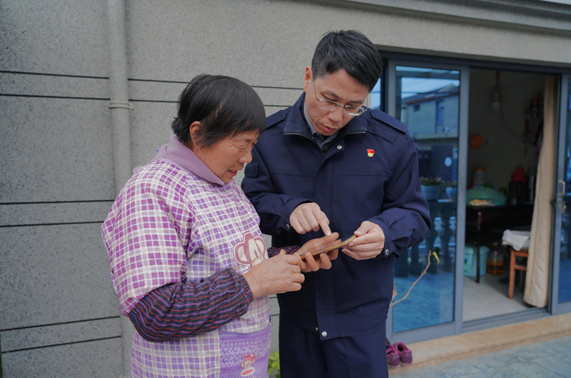 舟山市烟草专卖局工作人员陈亮上门为老年零售户指导线上业务办理。舟山烟草供图