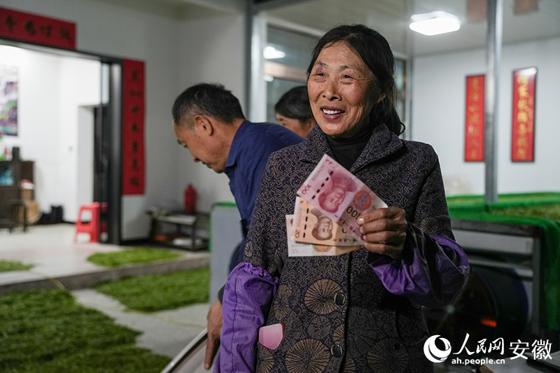 茶农拿着一天的采茶收入喜笑颜开。人民网记者 王锐摄