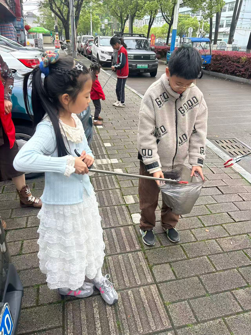 孩子们在社区内清理烟头。路南街道供图
