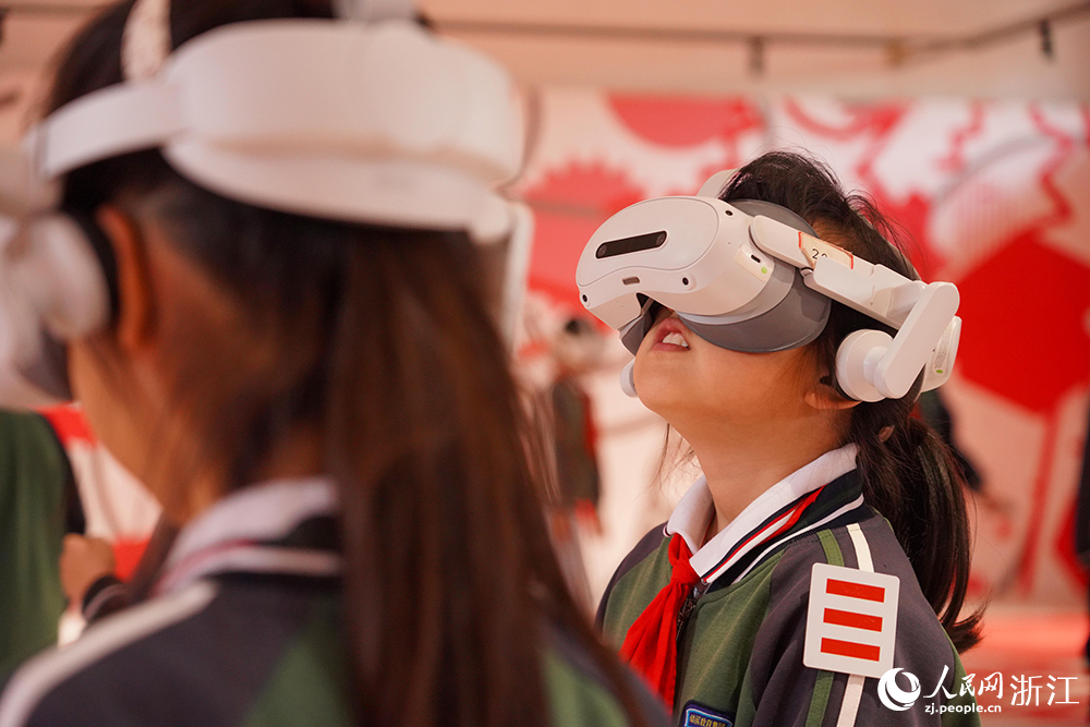 5月8日，浙江省嘉兴市秀洲区新塍镇小蓬莱剧场内，学生们佩戴VR眼镜，沉浸式感受数字阅读虚实交融、身临其境的全新体验。人民网 章勇涛摄